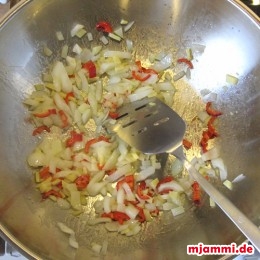 Nochmal 1 EL Öl im Wok erhitzen und damit die Zwiebeln und Chilieschoten anbraten bis die Zwiebeln leicht braun sind.