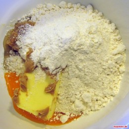 Για την ζύμη χωρίζουμε τον κρόκο από το αυγό και βάζουμε στην άκρη το ασπράδι. Βάζουμε το αλεύρι, το βούτυρο, την ζάχαρη, την φιστικόκρεμα και τον κρόκο του αυγού στην λεκάνη της μηχανής κουζίνας και ζυμώνουμε με το γάντζο για ζύμωμα. 