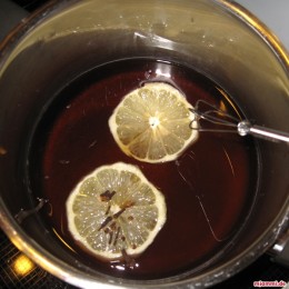 In einem kleinen Topf 1 1/2 Tasse Zucker in Wasser auflösen und die Zitronenscheiben sowie die Nelken dazu geben.